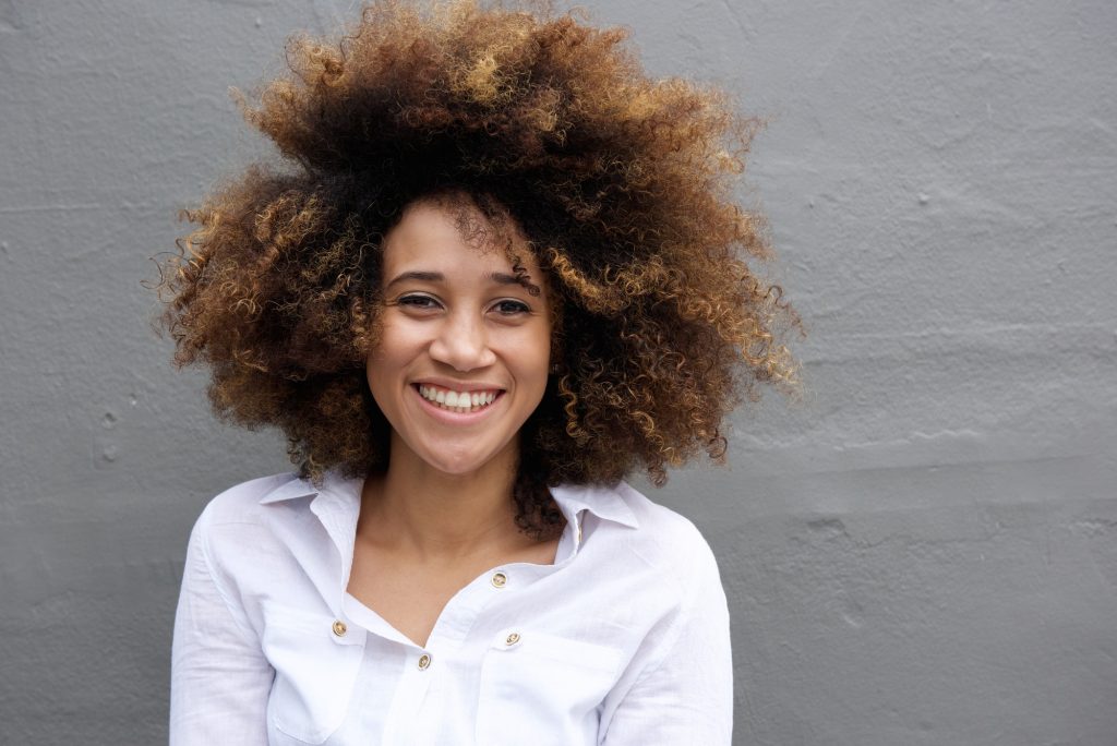 Smiling young woman with afro hair
